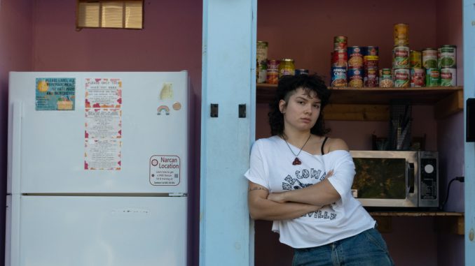 Mariabella Rivera-Todaro standing in front of the free food fridge they created in 2021. Everything in the shed is free for those in need to take.